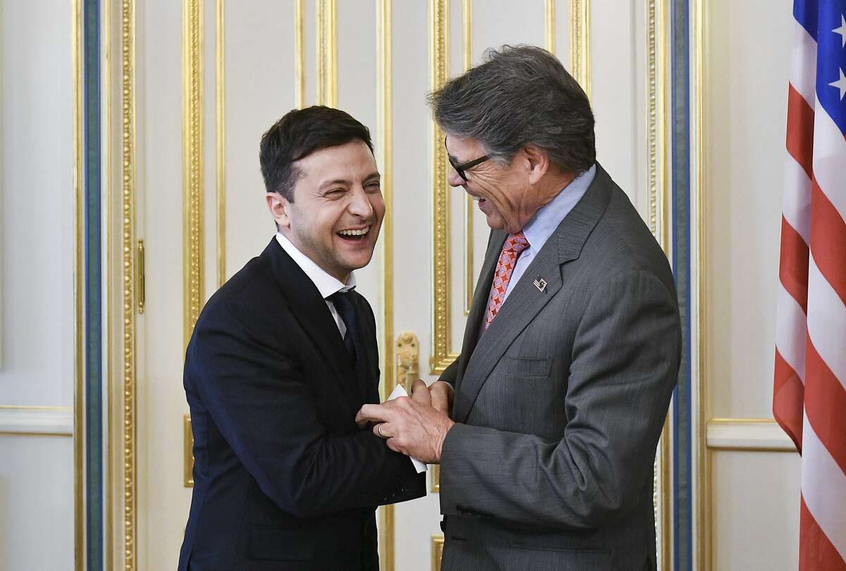 Ukrainian new President Volodymyr Zelenskiy, left, and US Energy Secretary Rick Perry share a joke during their meeting in Kiev, Ukraine, Monday, May 20, 2019. Television star Volodymyr Zelenskiy has been sworn in as Ukraine's next president after he beat the incumbent at the polls last month. (Mykola Lazarenko/Presidential Press Service Pool Photo via AP)