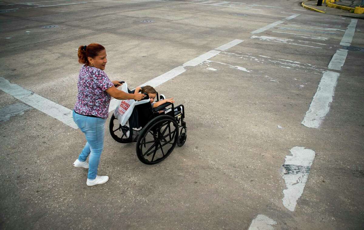 Gina Rios crosses Fulton Street at Quitman street with her grandson Mason, 1, where the paint marking the crosswalk is worn away in the Near Northside neighborhood of Houston on Oct. 9.