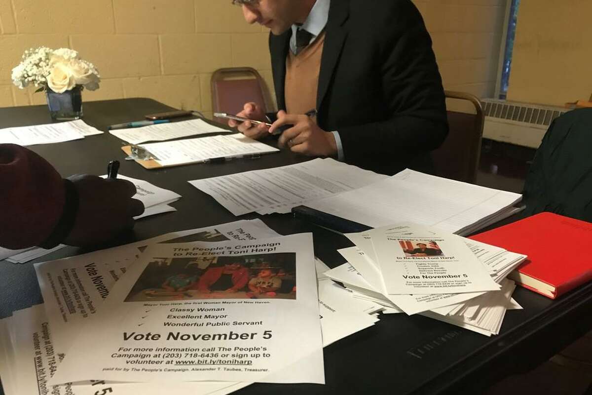 Mayor Toni Harp supporter Alex Taubes collects contact information and reminds them to vote for Harp in next month's election at an Oct. 9, 2019 event.