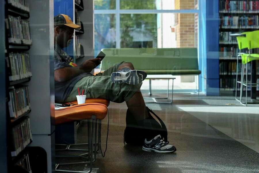 Jason Lewis hangs out in the video game section of the McGovern-Stella Link Library Tuesday, Oct. 1, 2019, in Houston. Two years ago, this library was one of 12 library branches in Houston and Harris County to close due to water damage from Hurricane Harvey.
