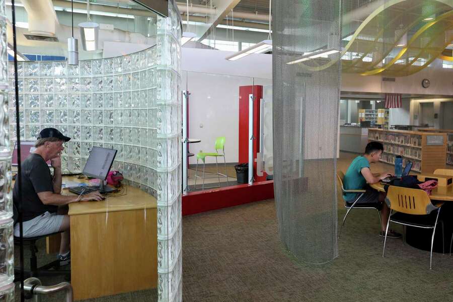 Byron Boyd, left, uses a computer at the McGovern-Stella Link Library Tuesday, Oct. 1, 2019, in Houston. Two years ago, this library was one of 12 library branches in Houston and Harris County to close due to water damage from Hurricane Harvey.