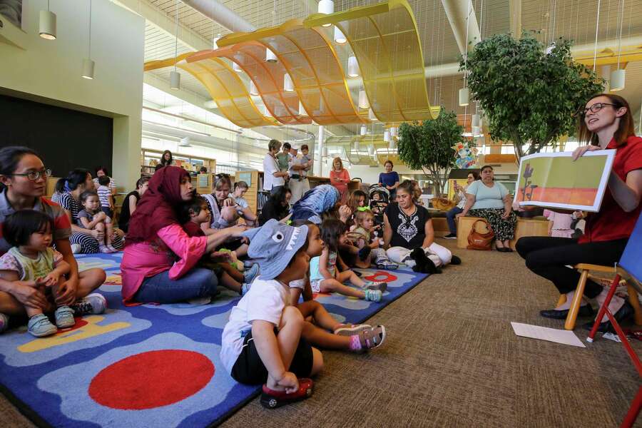 Youth manager Caitlin Campbell, right, leads a story time reading for toddlers inside the McGovern-Stella Link Library Tuesday, Oct. 1, 2019, in Houston. Two years ago, this library was one of 12 library branches in Houston and Harris County to close due to water damage from Hurricane Harvey.