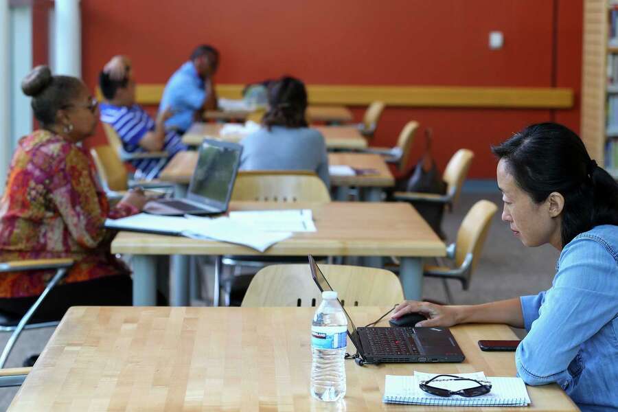 Joni Liu, right, uses her laptop inside the McGovern-Stella Link Library Tuesday, Oct. 1, 2019, in Houston. Two years ago, this library was one of 12 library branches in Houston and Harris County to close due to water damage from Hurricane Harvey.