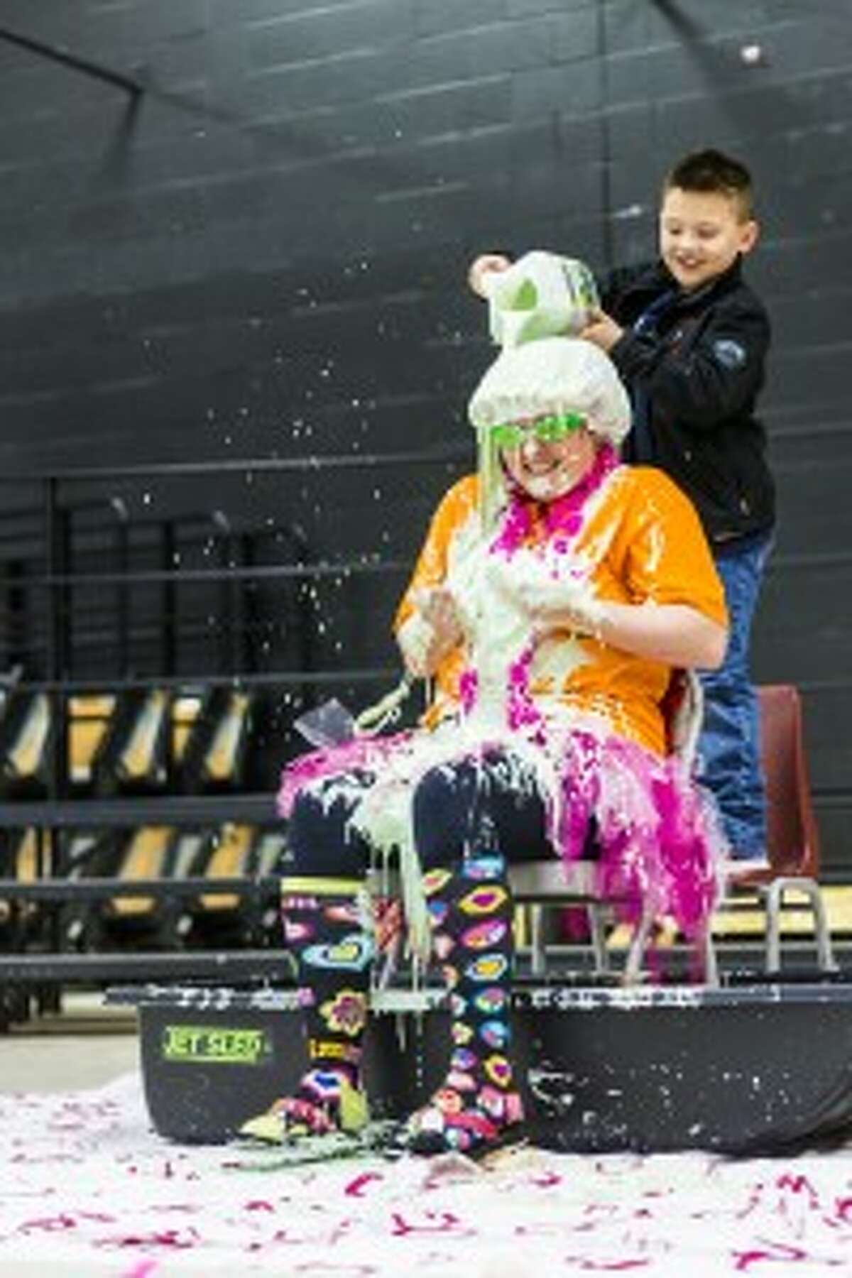 MAKING A MESS: The outfit of teacher Kylene Nix, consisting of a tutu, colorful socks and a bright orange shirt, are doused with slime by Hunter Trelour, a first-grade student.