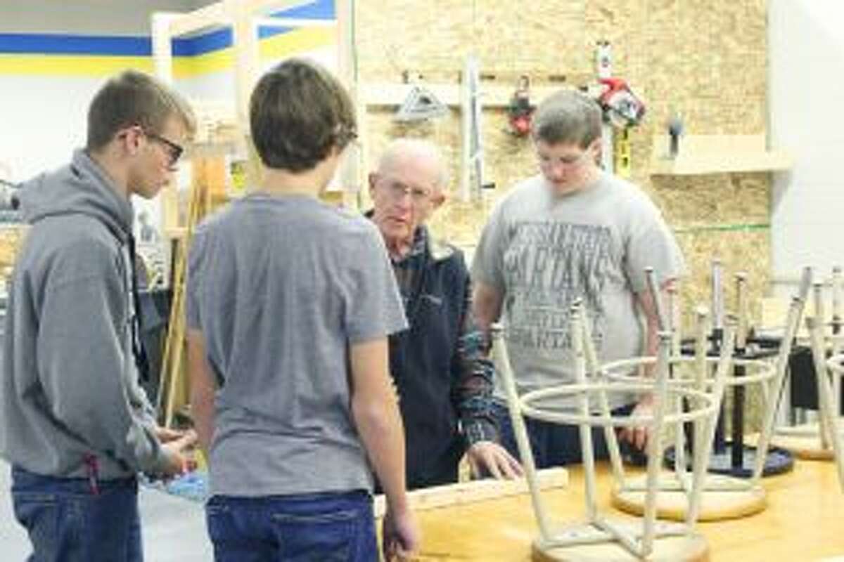 ADVICE: Jacob Kleeves, Ayden Aldrich and Trevor Henry listen to industrial arts instructor Jim Misner during the first few minutes of class on Thursday, Nov. 11. Misner came out of retirement to help restart the industrial arts program at Evart Public Schools.