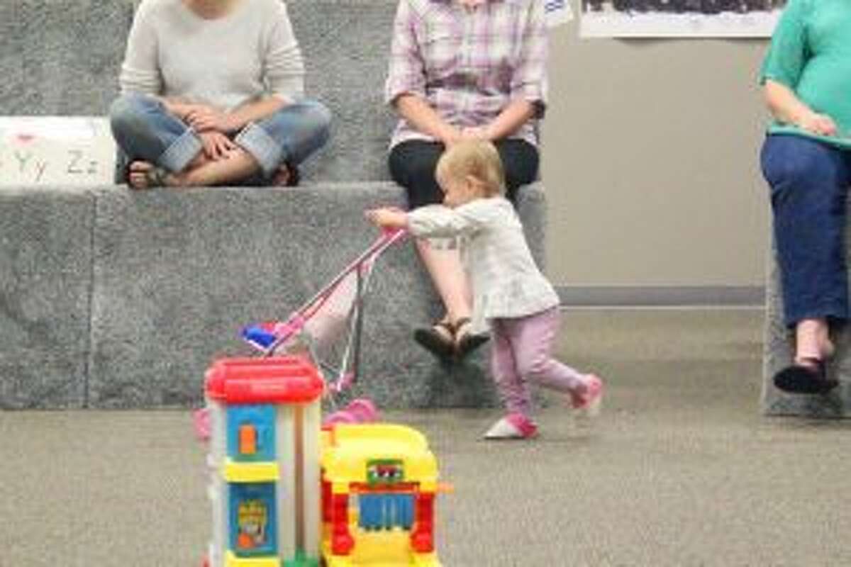 A LITTLE BIT OF EVERYTHING: Harper Juliano, 16 months, plays with a stroller during the playgroup on Thursday, Sept. 22.