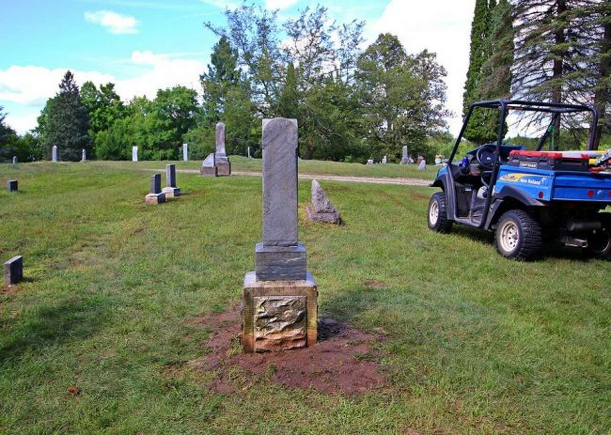 A completed headstone has been cleaned the ground around its base has been cleared away.