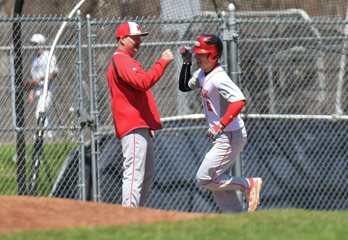 Enzo Merlonghi (5) of the Masuk Panthers gets a high five from coach Ralph Franco as he rounds third base after hitting a home run during a game against the Staples Wreckers at Staples High School on Saturday April 21, 2018 in Westport, Connecticut.