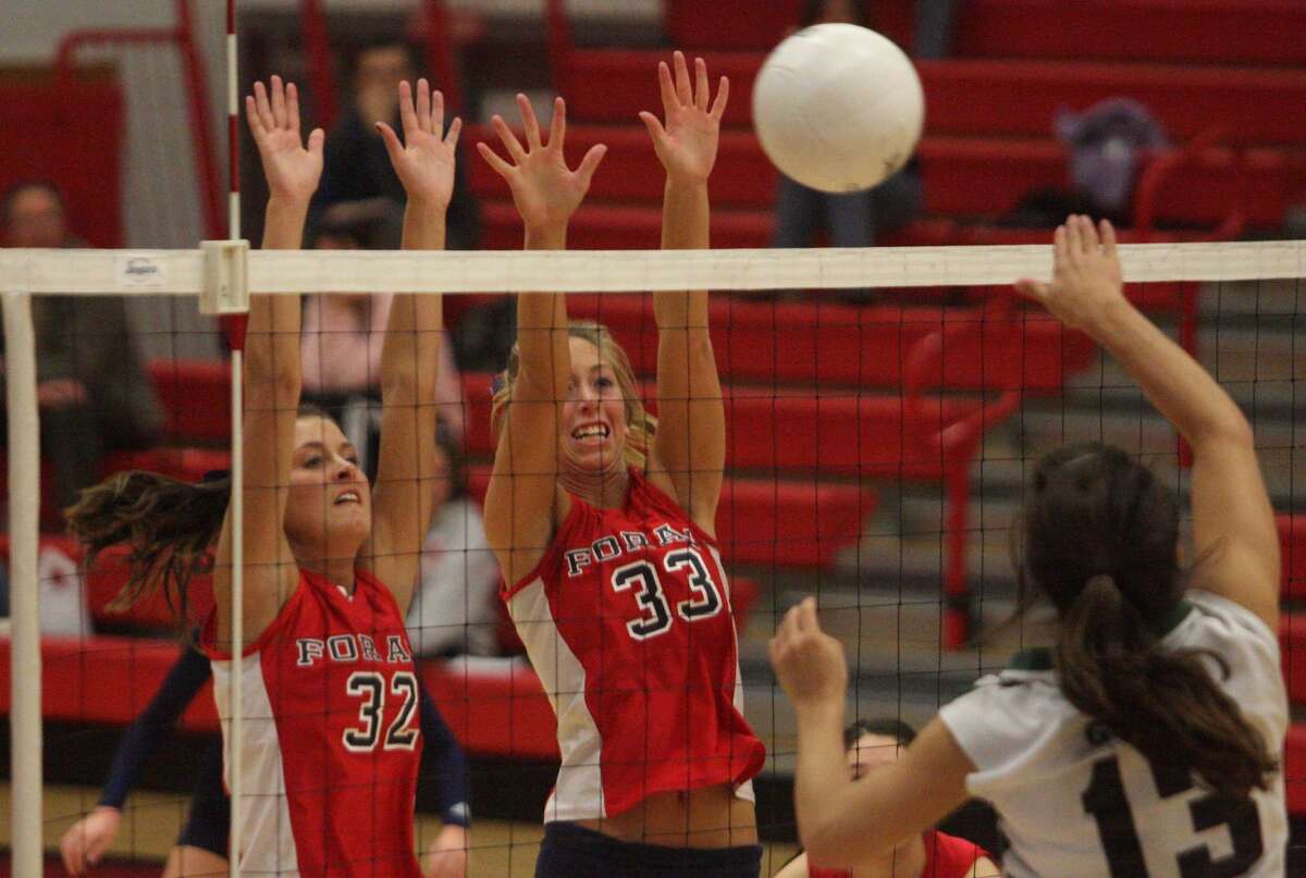 Foran's Annie Raucci (32) and Carli Matrisian block Guilford's Jenna Bellantoni in the Indians' 3-0 quarterfinal victory in the Southern Connecticut Conference tournament. (Photo by Russ McCreven).