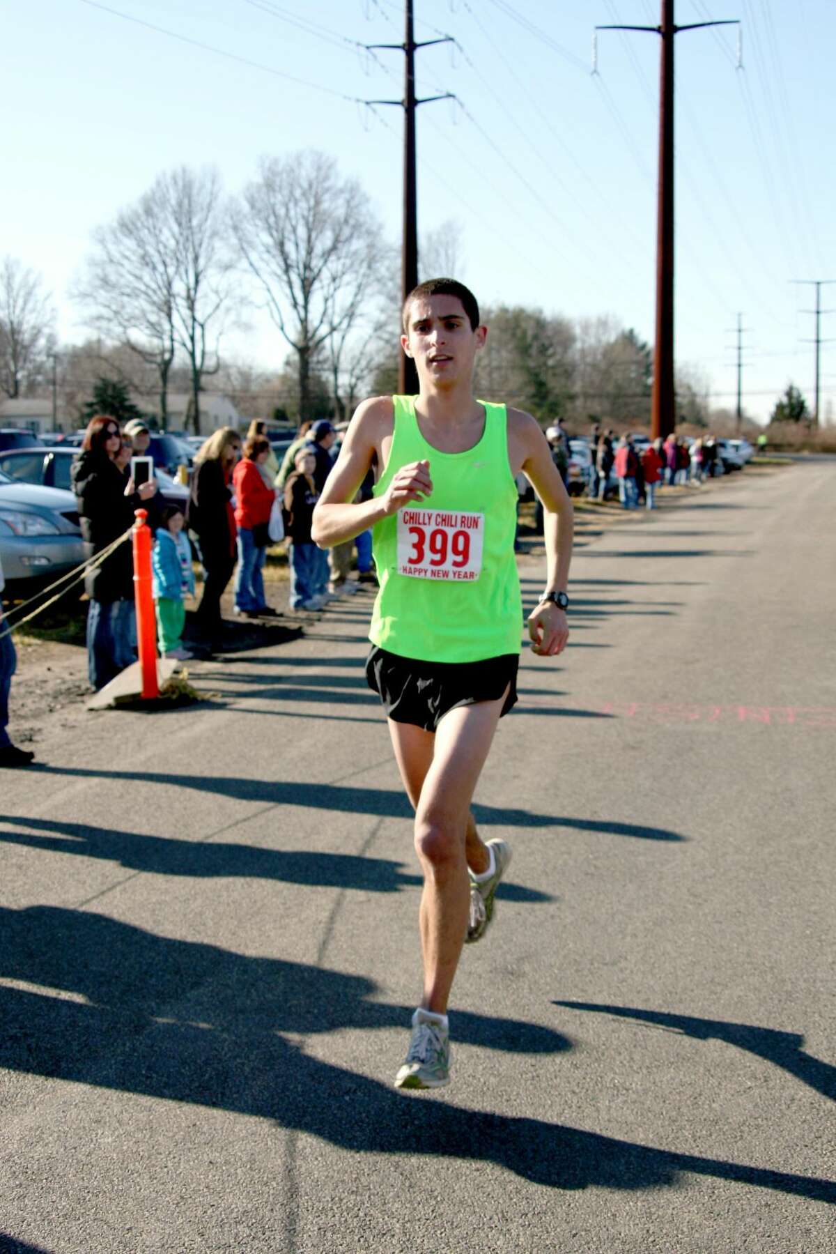 Photo by Bridget Albert - Overall Chilly Chili Run winner Matt Klein, 17, Trumbull prepares to cross the finish line. He completed the 5k in 16:05 minutes averaging a 5:11 minute mile.