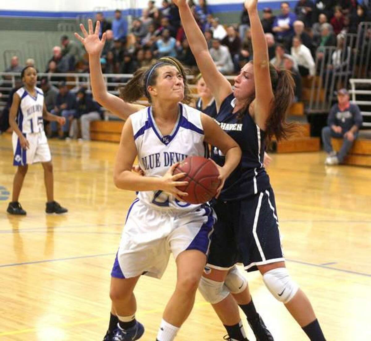 Photo by Russ McCreven West Haven's McKenzie Farquharson eyes the basket as she makes her way past two East Haven defenders.