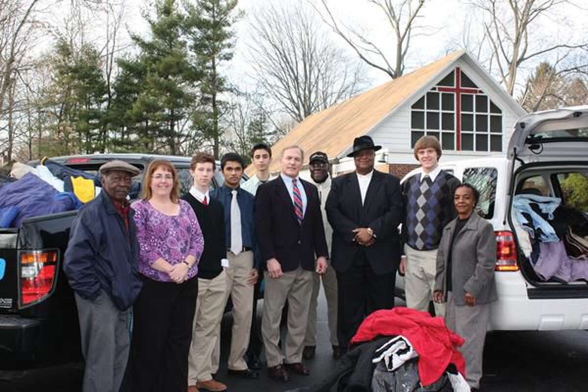 Submitted Photo Pictured left to right: Louise Goldbeck, teacher at Jonathan Law High School; students from Jonathan Law High School who helped with the coat drive; Carter Mario, President & CEO of Carter Mario Injury Lawyers; Pastor Calvin Robinson; and Laura Williams of The First Baptist Church of Milford.