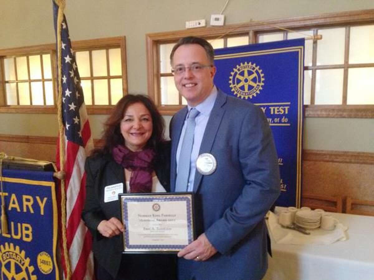 Submitted Photo Tina DeNapoles, president of Milford Rotary, left, presents the Norman K. Parsells Award to Eric Tashlein.