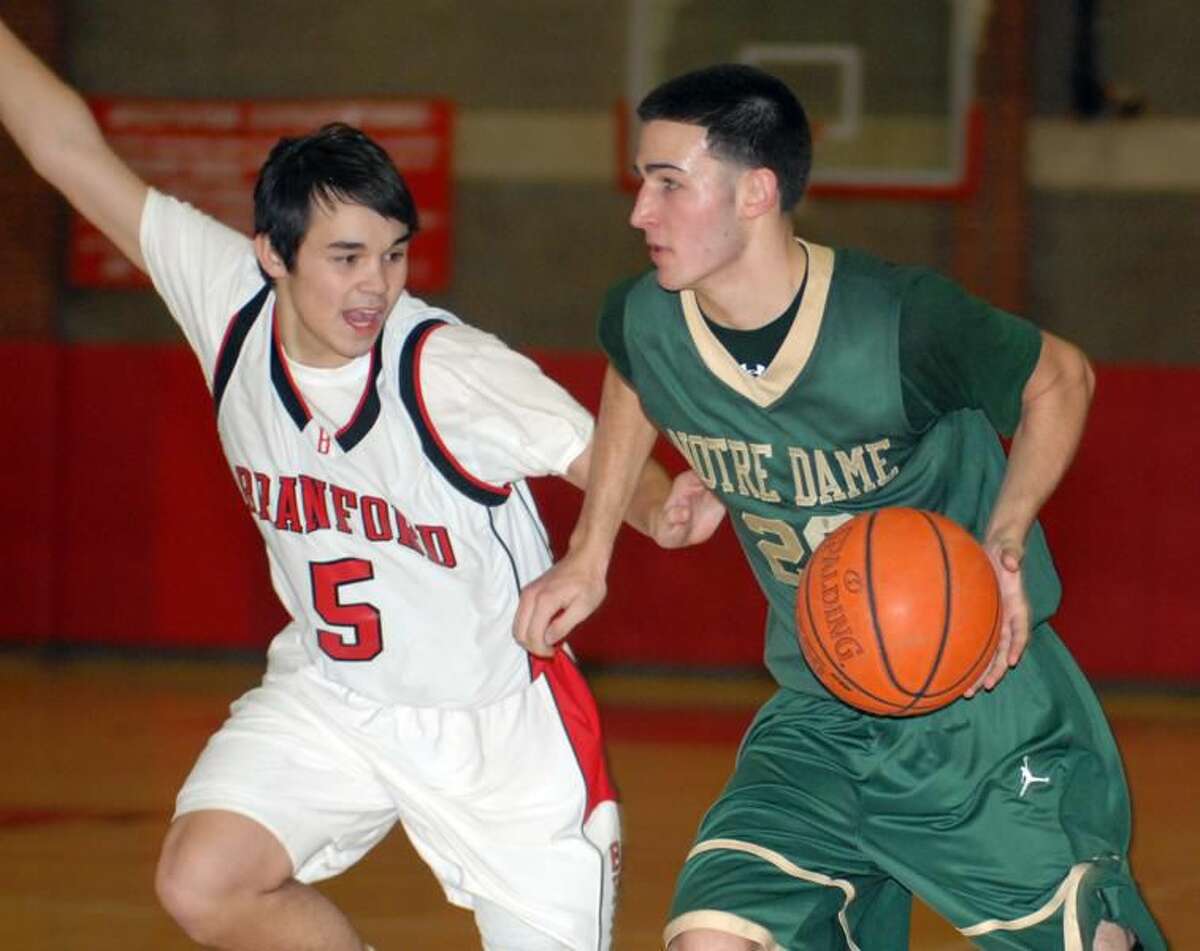 Photo by Dave Phillips Notre Dame's Tom Doyle dribbles past Branford's Connor Moriarty.