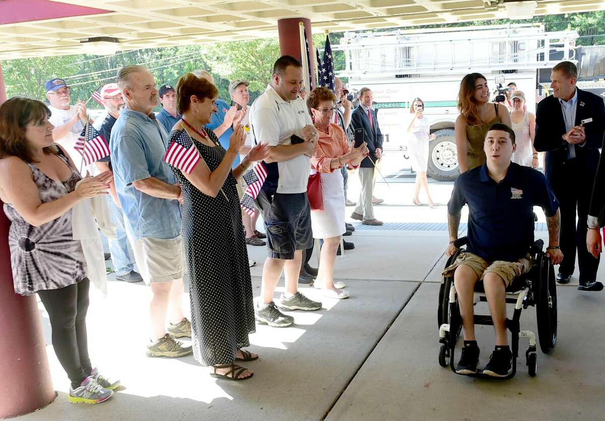 Peter Hvizdak New Haven Register Army veteran Sean Pesce, 24, wounded in 2012 in Afghanistan and paralyzed from the waist down, right, arrives Aug. 13 at Amity Regional Bethany Middle School.