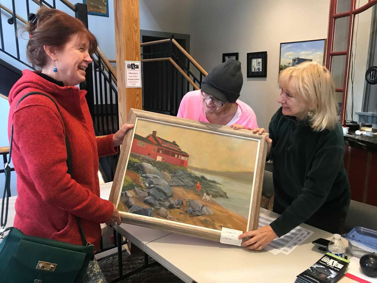 Artist Cathy Liontas, here with Arlene Morrell and Gayle Caro, submits an oil painting she entered into the judged exhibit.