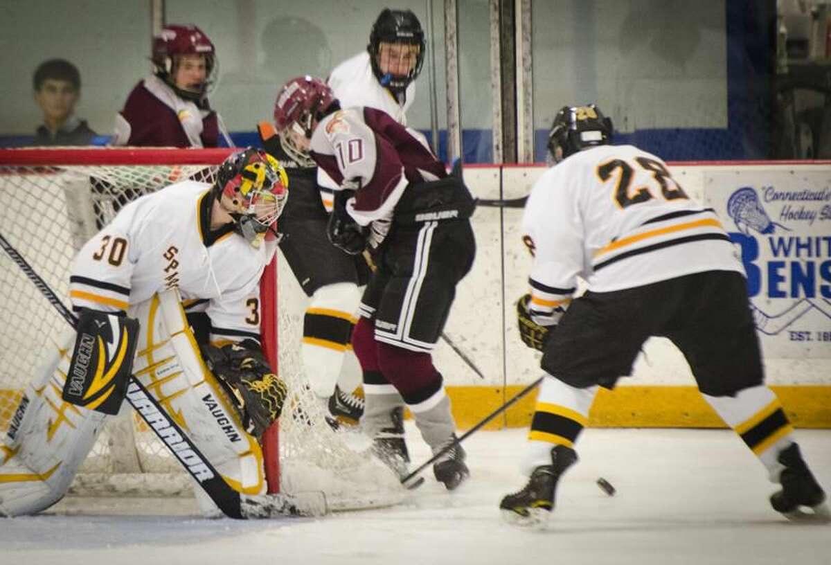 (Melanie Stengel — Register) Milford's Brandon Argyros is caught betweeen Amity's Dalton Luciani and Keating Seymour in 2nd period action 1/8. Keeping an eye on the puck is Amity goalie,Brian Mosher.