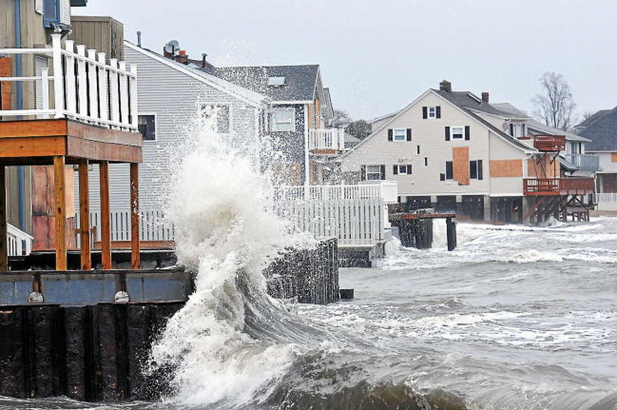Waves slam against the homes along Cosey Beach in East Haven during low tide.