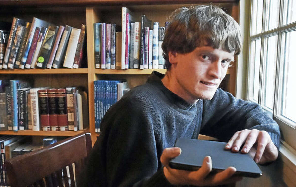 Madison resident Tommy Canning,22, holds his IPad, Wednesday, March 22, 2017, at the Atwater Library at 1720 Foxon Road in North Branford. Canning, who hopes to have a series of books he has written about animals and the environment published, will be holding workshops across the state at different libraries to get feedback on his work.
