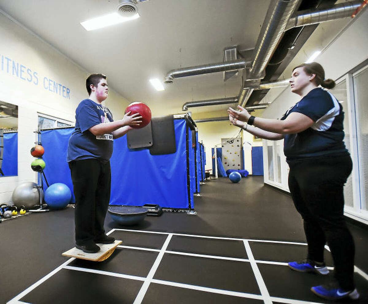 Standing on a balance board, Nick Keating, 16, passes a medicine ball to head trainer, Jackie Sanca, during a 30-minute personal training session at the ASD Fitness Center, 307 Racebrook Road, Orange.