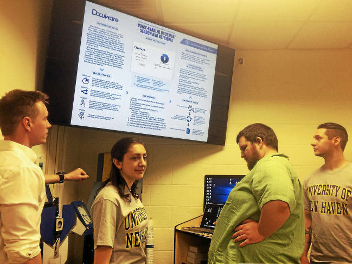 University of New Haven computer science students Samuel Perreault of Providence, R.I., Arianna Conti of Brewster, N.Y., Donald Sbabo of North Haven and Joseph Ricci of North Haven talk about the new voice recognition filing software program they created for DocuWare, a Wallingford-based document management company, as part of a senior project for Assistant Professor Frank Breitinger’s Senior Design class.
