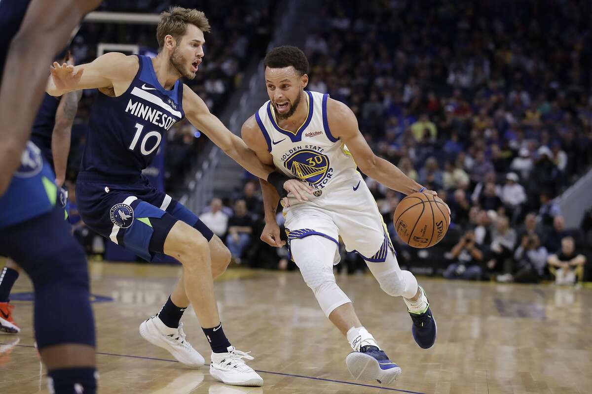 Golden State Warriors' Stephen Curry, right, drives the ball against Minnesota Timberwolves' Jake Layman (10) during the first half of an NBA preseason basketball game Thursday, Oct. 10, 2019, in San Francisco. (AP Photo/Ben Margot)