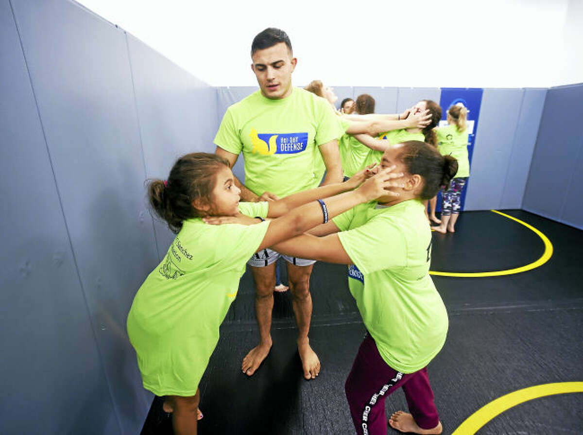 Instructor and Fighting Arts Academy owner Nick Newell (center) observes Kamille Perez (left), 8, and Naralis Velazquez, 9, of Bridgeport practice how to counter an attacker during a self defense class hosted by the Maren Sanchez Home Foundation at the Fighting Arts Academy in West Haven on September 17, 2017. Arnold Gold / Hearst Connecticut Media