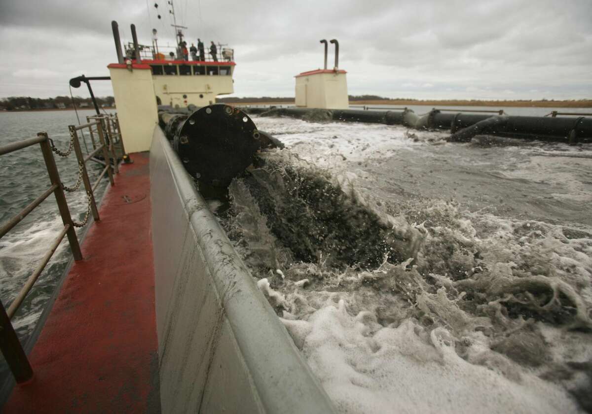 Sand vacuumed from the bottom of the Housatonic River pours into a central hopper on the dredging vessel Currituck in Stratford, the last time that the Housatonic was dredged in Nov. 2012. A new and more ambitious dredge project will begin this week on the Housatonic, between Stratford and Milford.