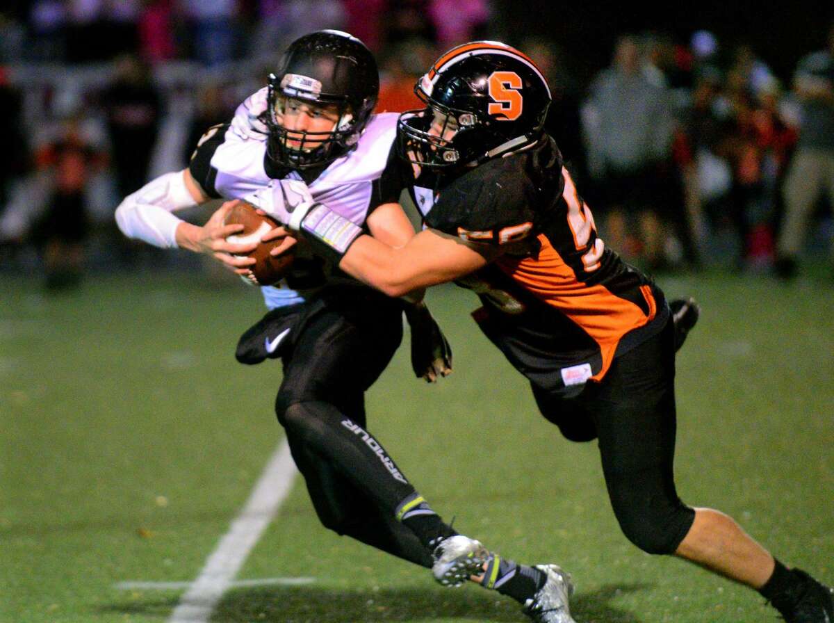 Shelton's Ray Weiner attempts to tackle Amity QB James Laubstein during football action in Shelton, Conn. on Friday Nov. 3, 2017.