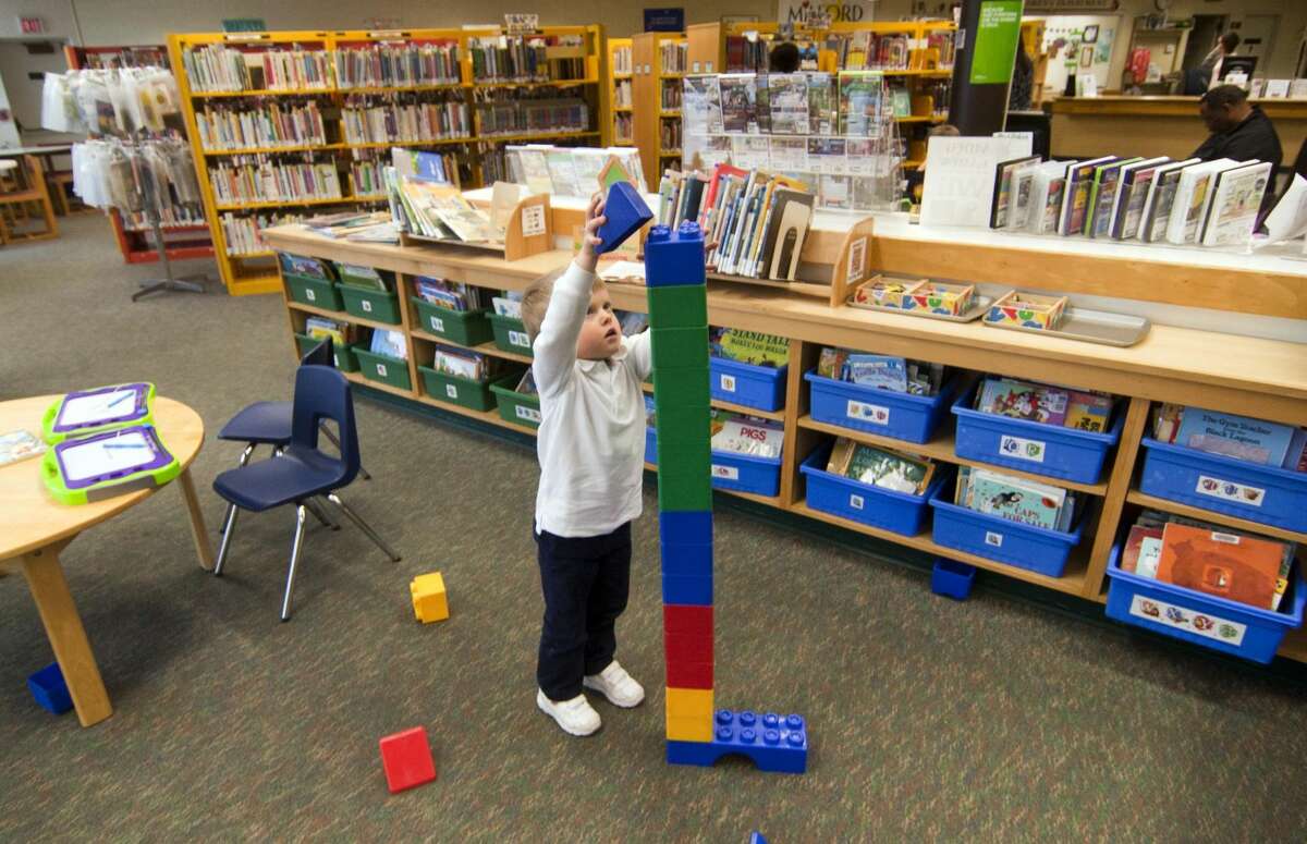 Brennan Lawless, 3, of Milford, builds a Lego tower while playing at the Milford Public Library.