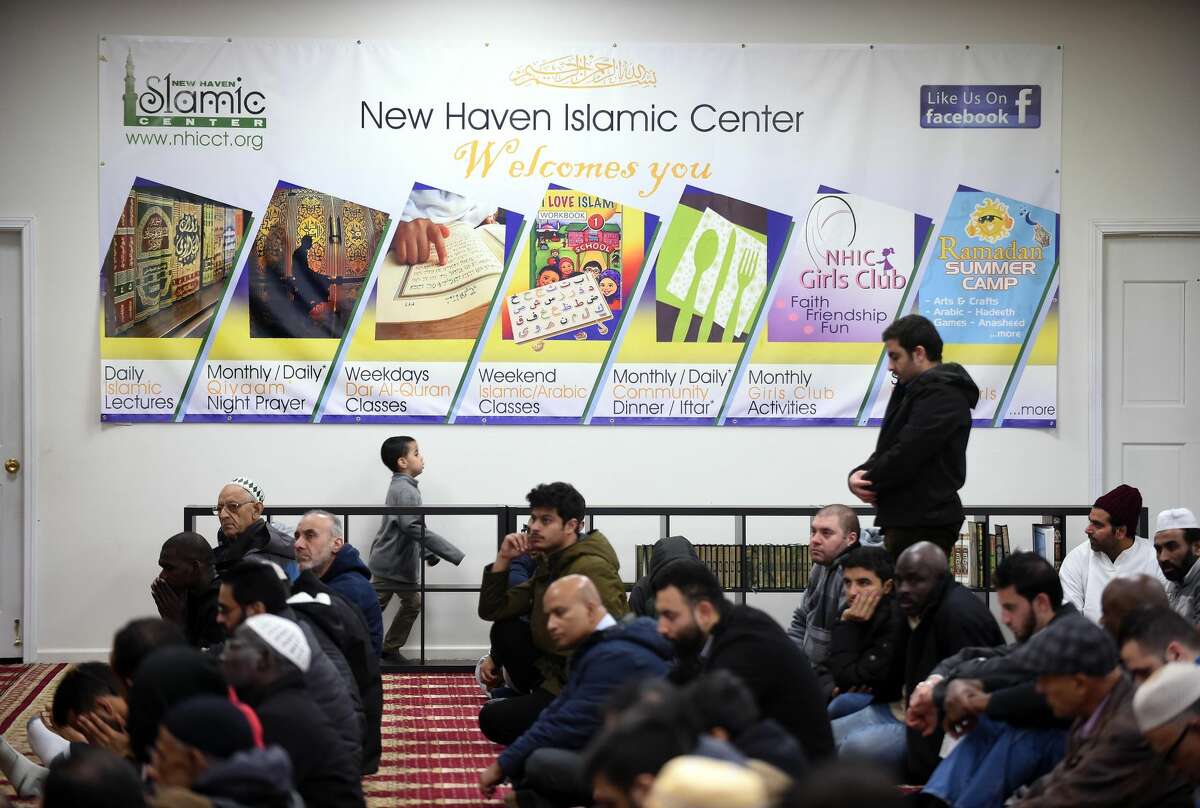 Men listen to a sermon by Imam Bachir Djehiche before a Friday prayer service at the New Haven Islamic Center in Orange on December 22, 2017.