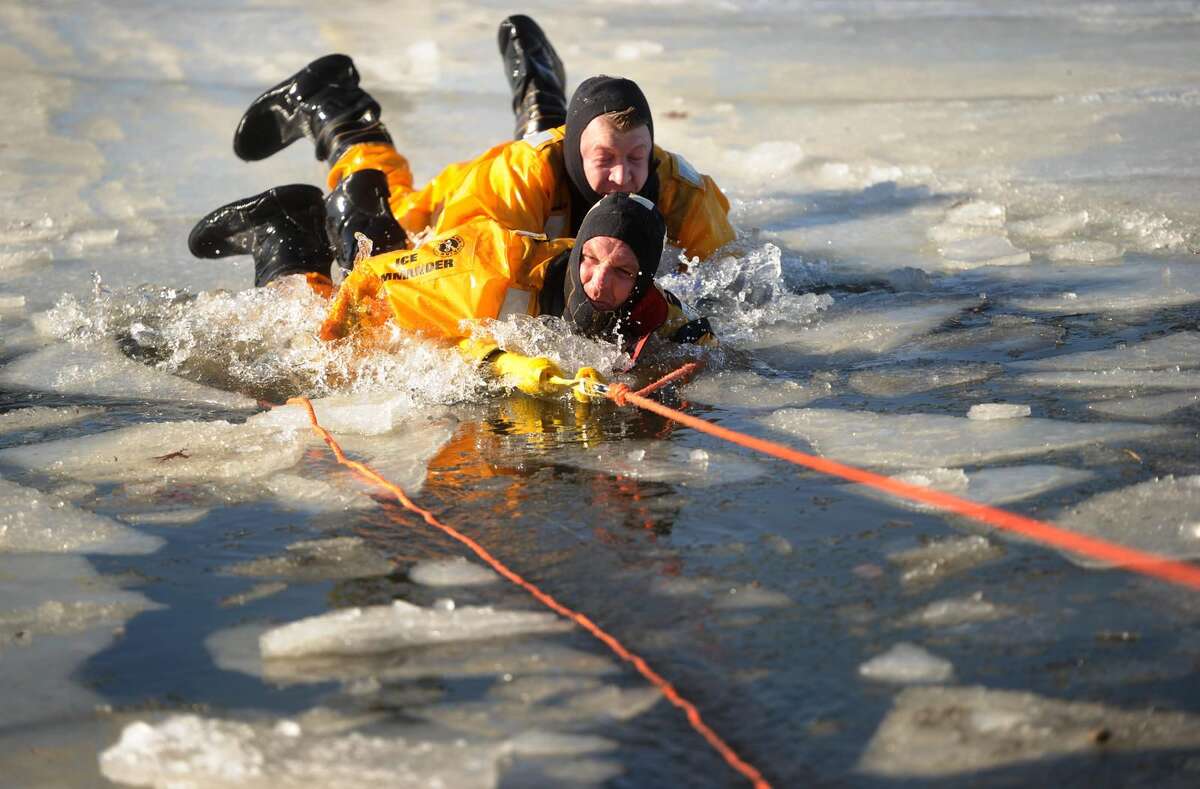 Milford firefighters C.J. Staiger, top, and Tom Sarno practice cold water ice rescue techniques with the Milford Fire Department on Milford Harbor.