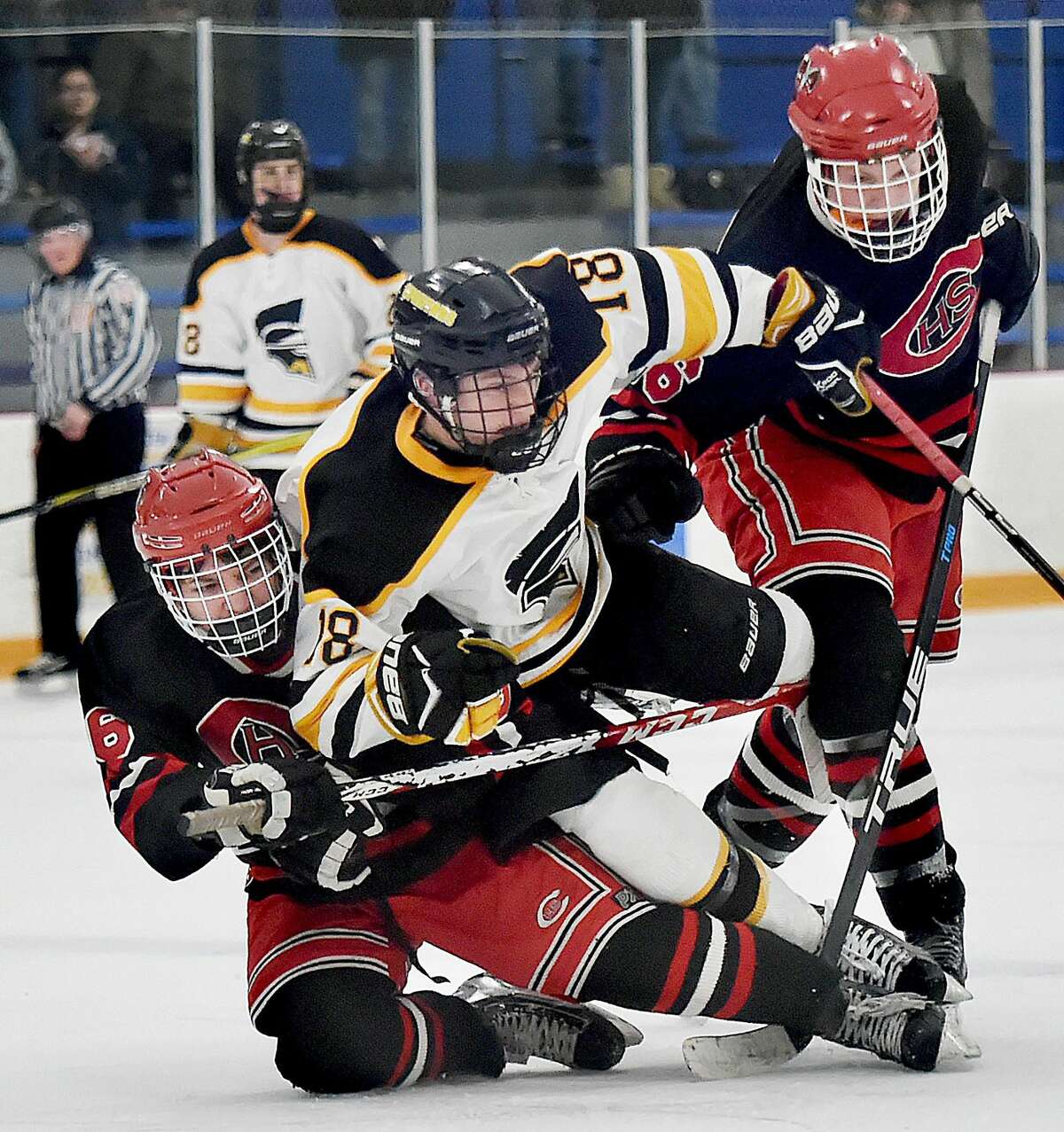 Amity junior forwared Jason Csejka (18) battles Cheshire junior forwards Jason McKinley (6) and Evan Veivia (16), Wednesday, Jan. 31, 2018, at Bennett Rink in West Haven. The Spartans tied the Rams, 4-4 in regulation, and a scoreless overtime.