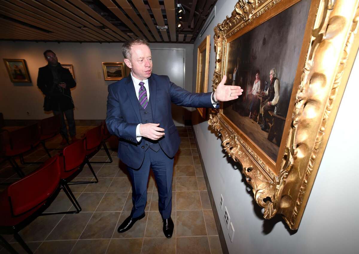 Ciaran Cannon, Irish Minister of State at the Department of Foreign Affairs and Trade, views the oil painting, Mending the Nets, from 1886 by Howard Helmick during a visit to Quinnipiac University's Great Hunger Museum in Hamden on February 8, 2018.