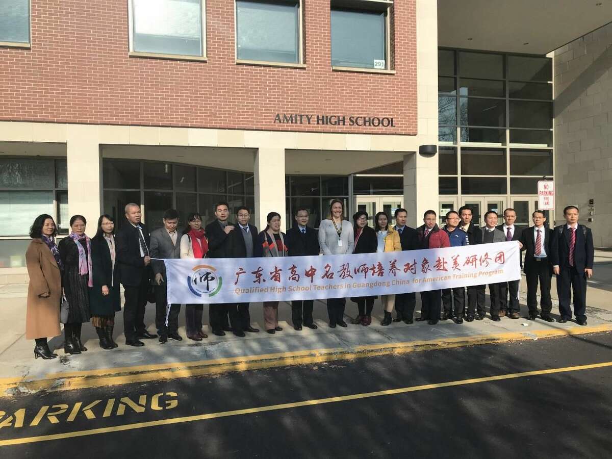 The full delegation posed with principal of Amity Regional High School, Anna Mahon, in front of the school