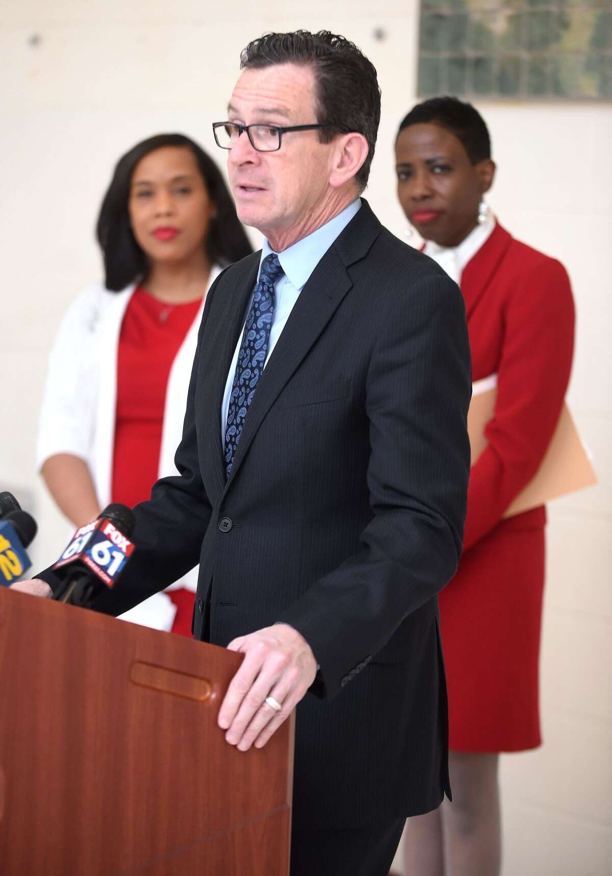 Wilbur Cross High School principal Edith Johnson, left, and New Haven Superintendent of Schools Carol Birks listen to Gov. Dannel P. Malloy announce 2017 statewide graduation statistics at Wilbur Cross High School in New Haven on