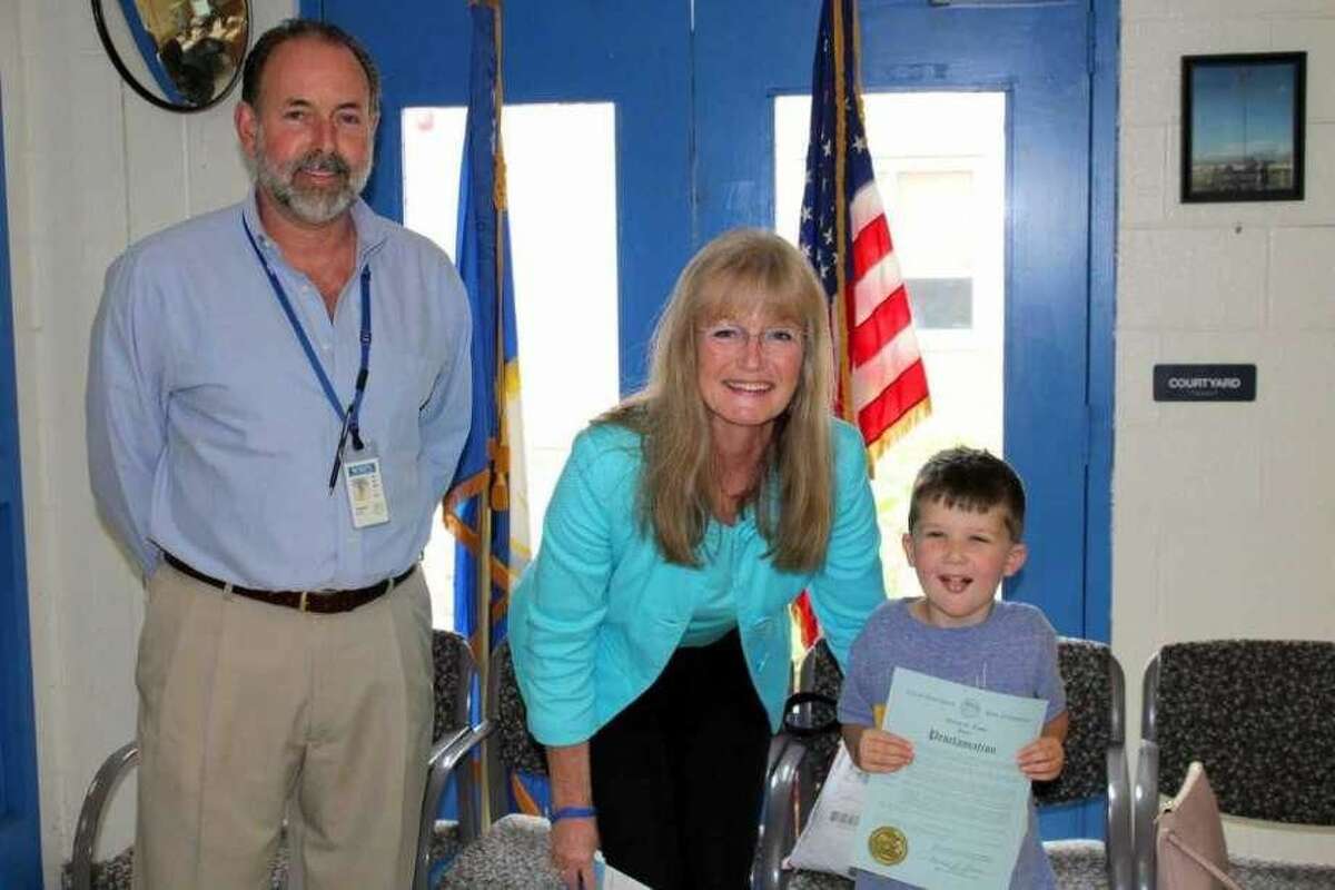 West Haven Mayor Nancy Rossi presents Forest Elementary School kindergartner Nicholas Gorske, right, a proclamation declaring Apraxia Awareness Day in West Haven. At left is school Principal Thomas J. Hunt.