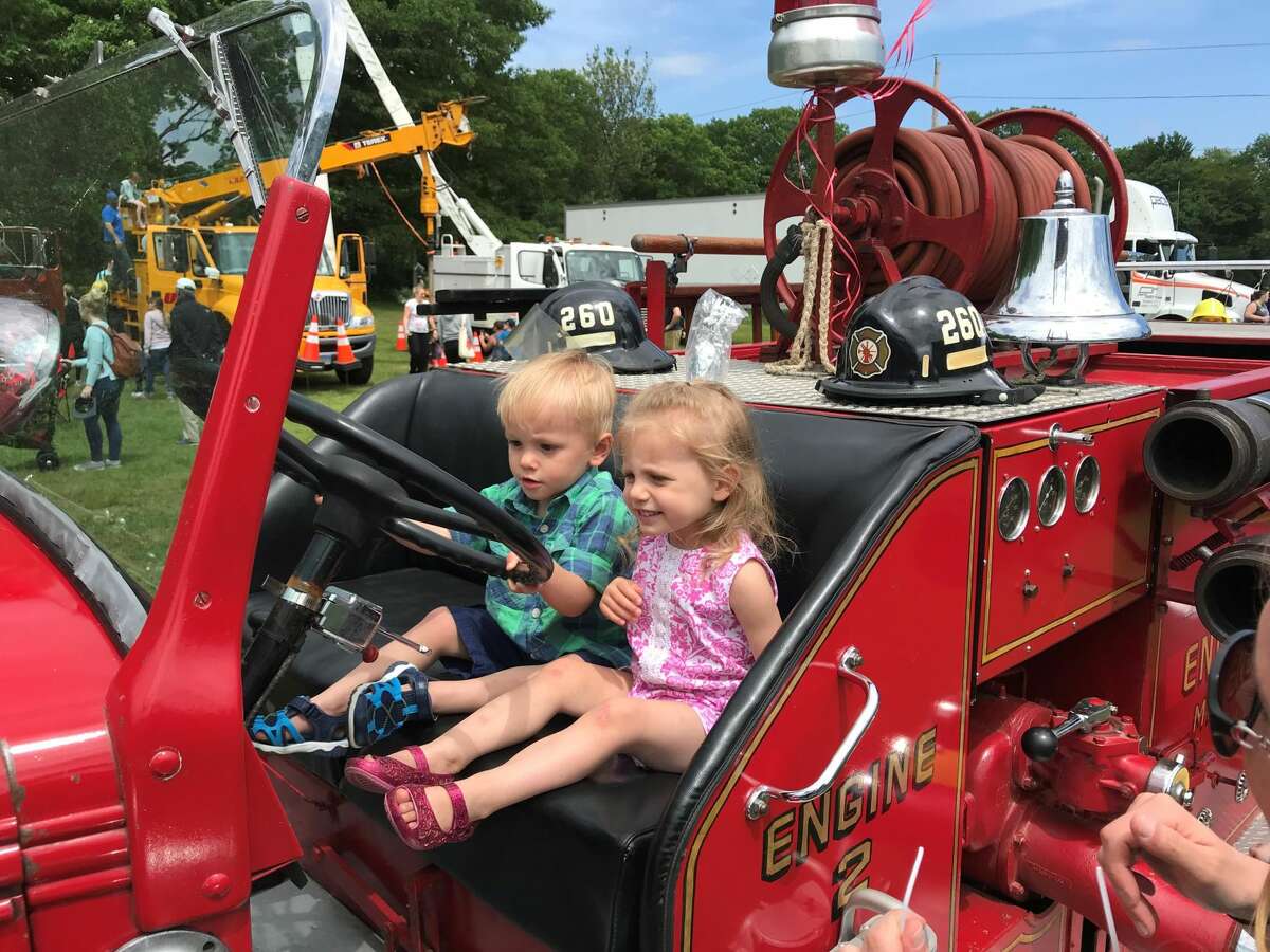 Two-year-old twins Eric and Victoria Sauter at the wheel of a firetruck.