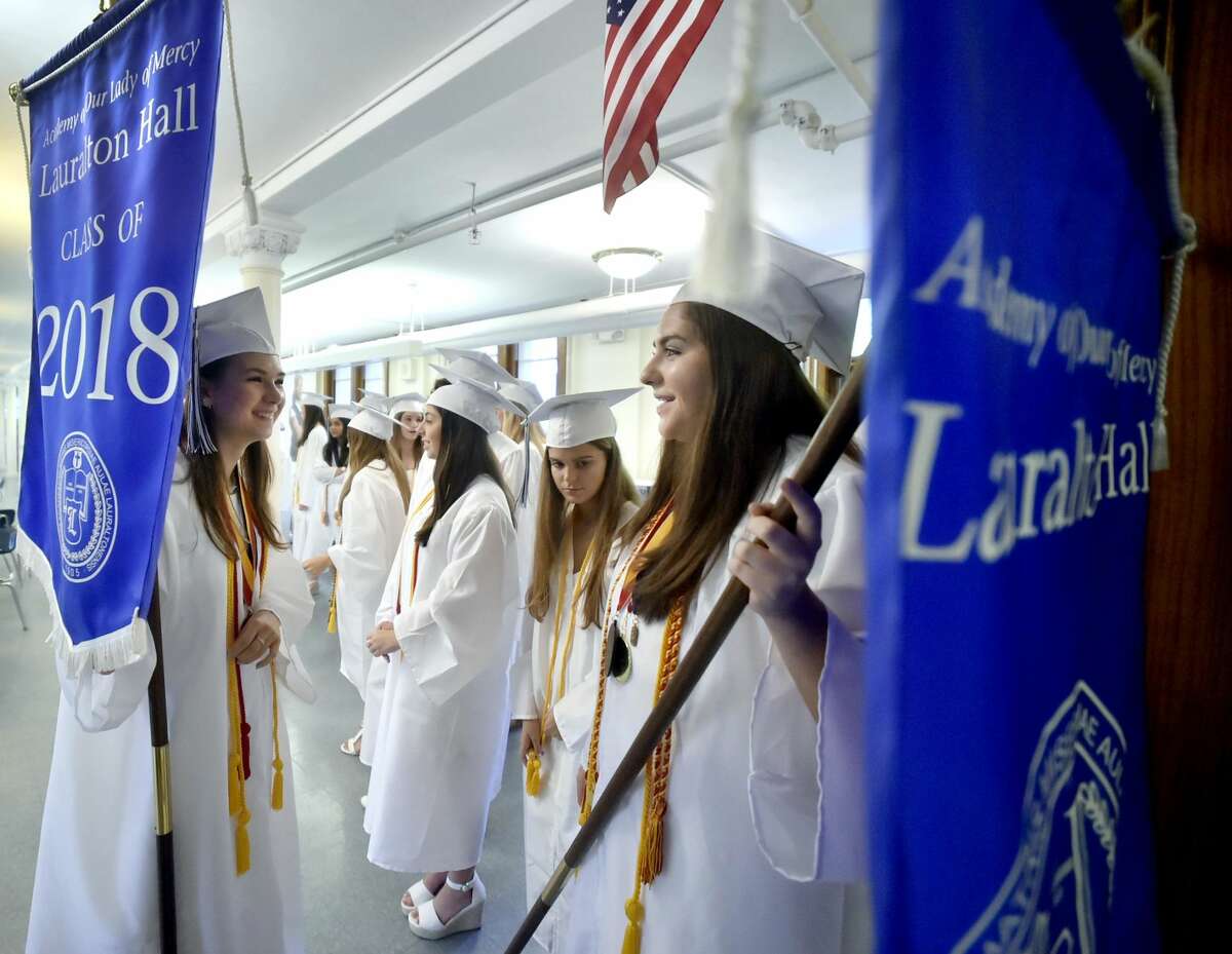 Lauralton Hall Salutatorian Lily Wald of Derby, left, and Valedictorian Caroline Favano of Norwalk, right, hold on to Lauralton Hall banners as the wait to lead the Lauralton Hall Class of 2018 Graduation processional Saturday.