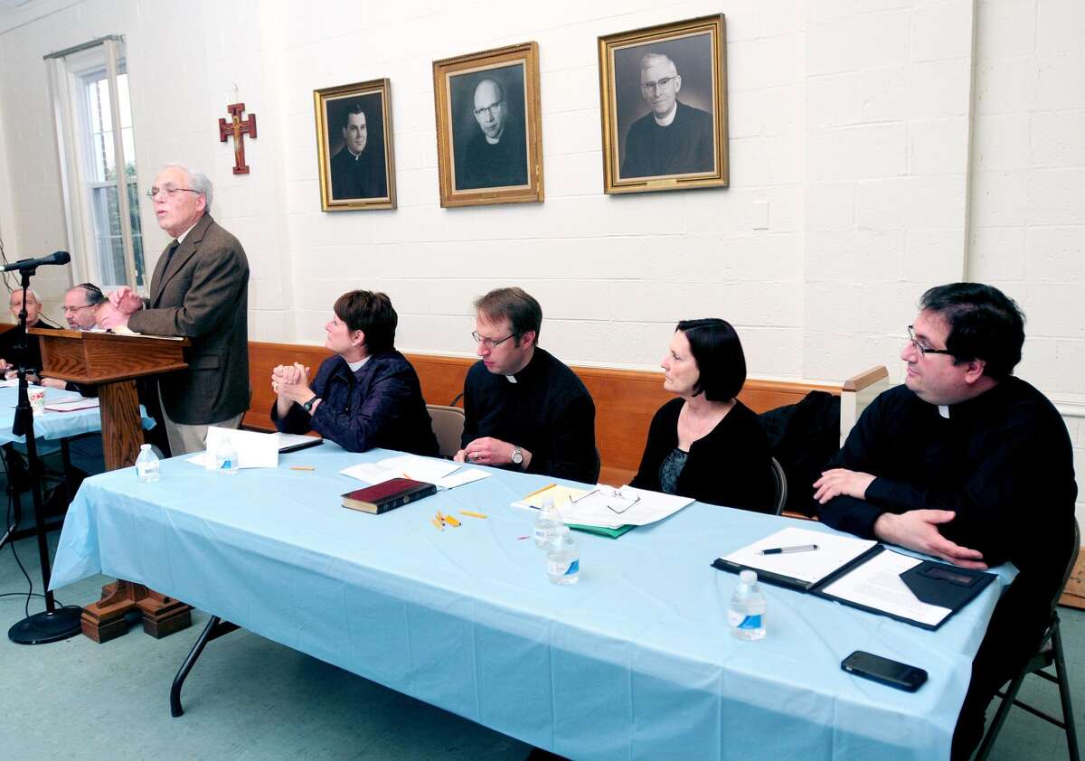 Dr. Julius Landwirth (left) speaks at a forum on physician-assisted dying at the Holy Infant Roman Catholic Church in Orange on March 30, 2014. Members of the Orange clergy seated left to right are Rev. Ann Ritonia of the Church of the Good Shepherd, Rev. Tim Boerger of Ziion Lutheran Church, Rev.Suzanne Wagner of Orange Congregational Church and Father Peter Orfanakos of St. Barbara Greek Orthodox Church.
