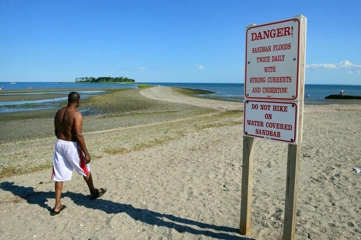 Several signs warn people about the tombolo, or sandbar, that leads to Charles Island at Silver Sands State Park in Milford. The signs have been posted to warn people about the dangers of using the land bridge which is covered by the tides on a daily basis.