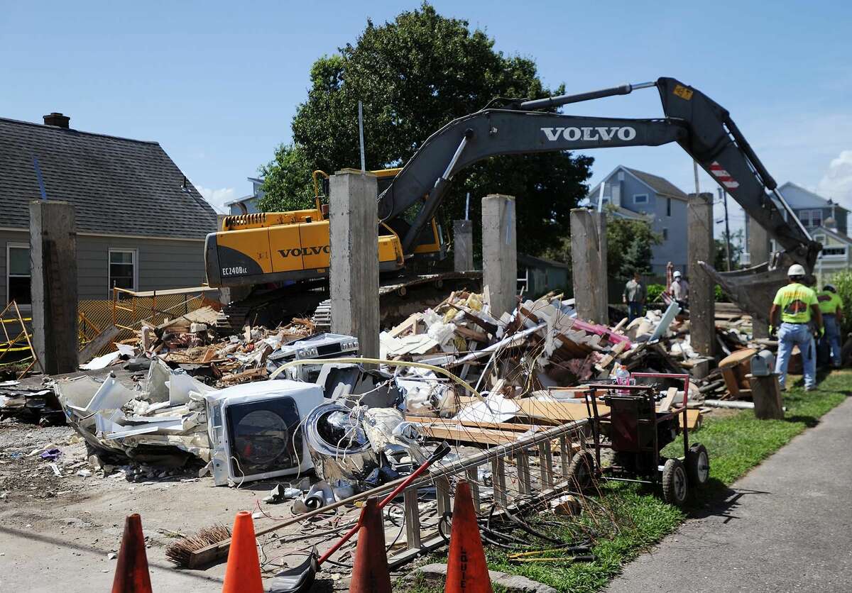 A home at 24 Cooper Avenue in Milford is demolished on Tuesday, July 24, after it collapsed while being raised on to new concrete pilings on Monday.