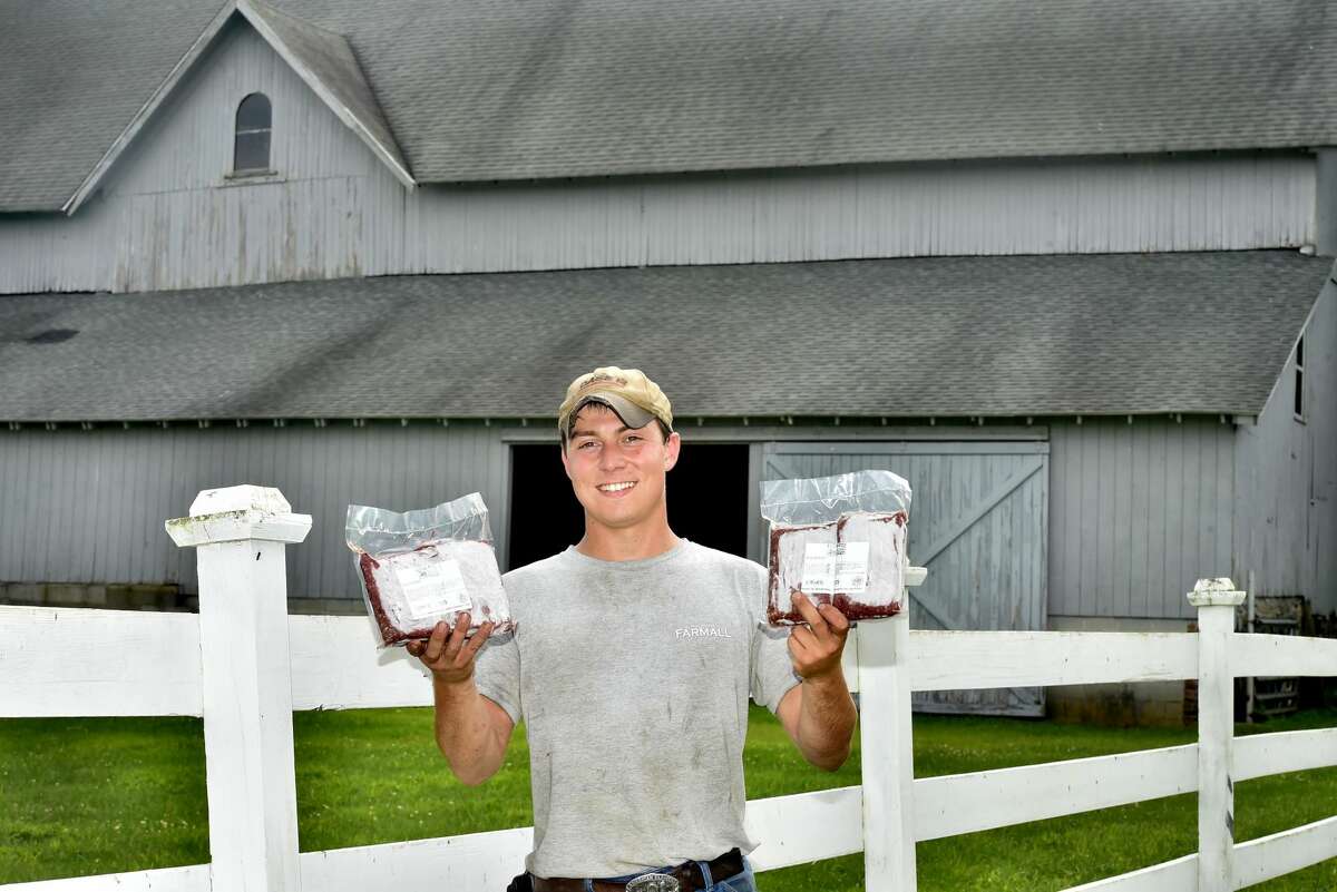 Cristian Mortali of Orange, a former employee of Shamrock Farm in Orange, holds frozen cryovac packages of USDA inspected organic beef from Hereford and Simmental Cattle at Jim Zeoli's Shamrock Farm in Orange.