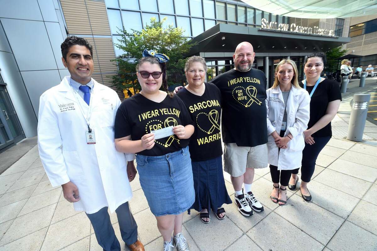 Madison Marcus, second from left, 14, of Orange with her mother, Paulette and father, Brad, donating $3525 she raised through a bake sale for the Phase I Clinical Trial Infusion Center, where her mother is being treated for breast cancer. From left are oncologist Dr. Navid Hafez, Madison Marcus, Paulette Marcus, Brad Marcus, oncology APRN Mandy DeMerchant and research coordinator Binaish Khan.