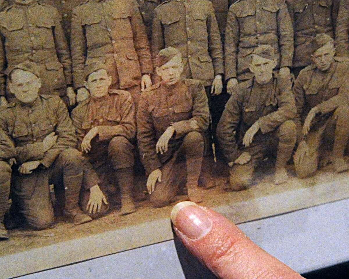 A woman points to a WWI-era photograph of her grandfather, who served in the U.S. Army. Monday night, the Cromwell Historical Society will hold a reception to mark the opening of its summer exhibit, “Cromwell & The Great War.”