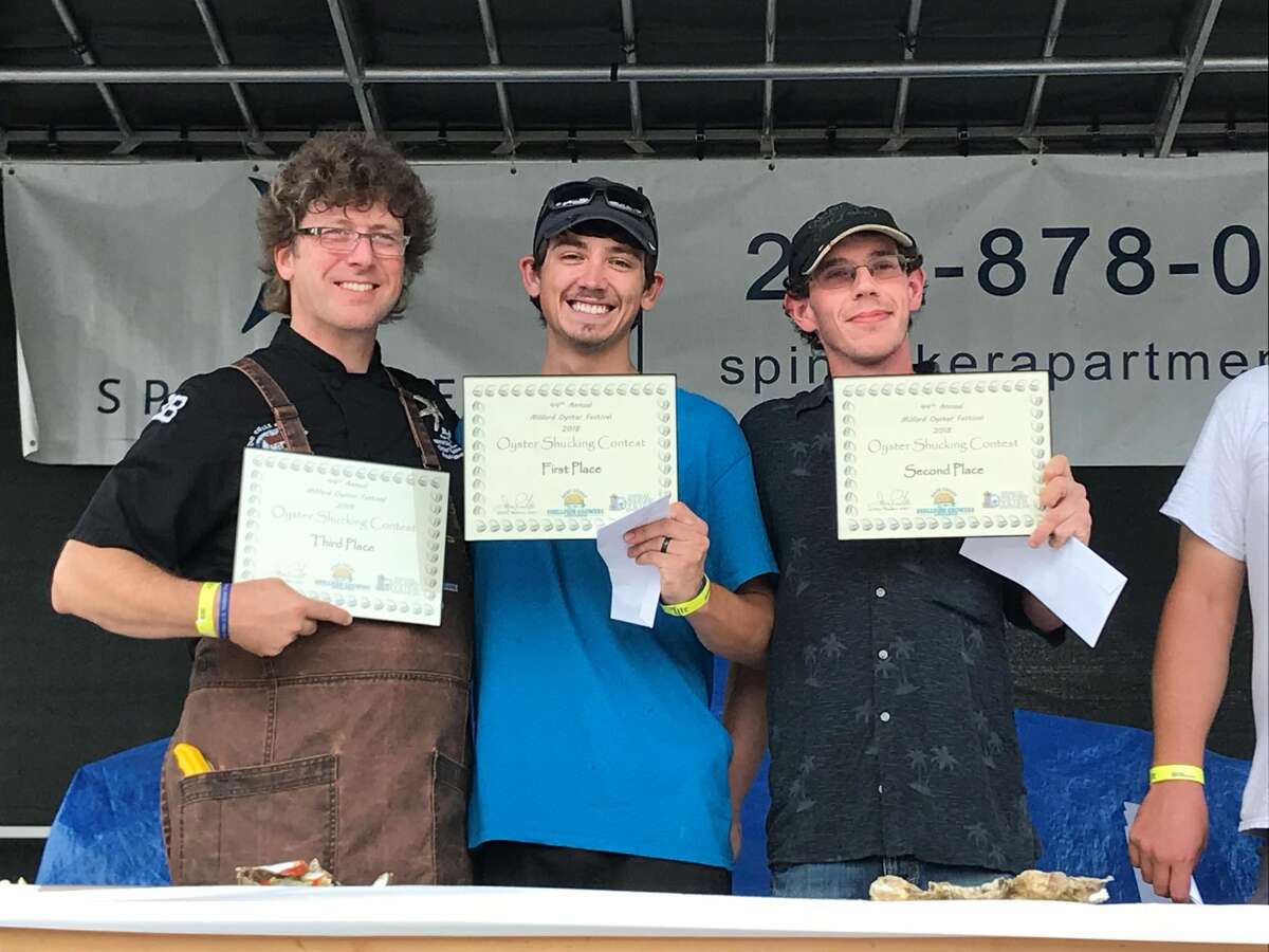Honor Allen, center, first place winner in the Oyster Shucking Contest at the Oyster Festival, with second and third place winners Ed Nead, right, and Eli Carter, left.