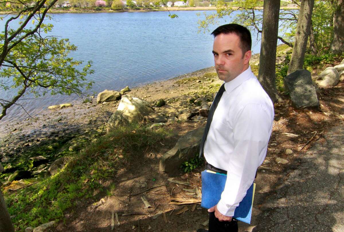 Milford Police Department's Detective Mitchell Warwick, who is responsible for two cold cases, stands near the scene of one of them on Old Oronoque Road in Milford. On March 24, 1994, public works came across a military-style duffle back near the Housatonic River off the side of Old Oronoque Road in Milford. Inside the bag, they found a man’s torso.