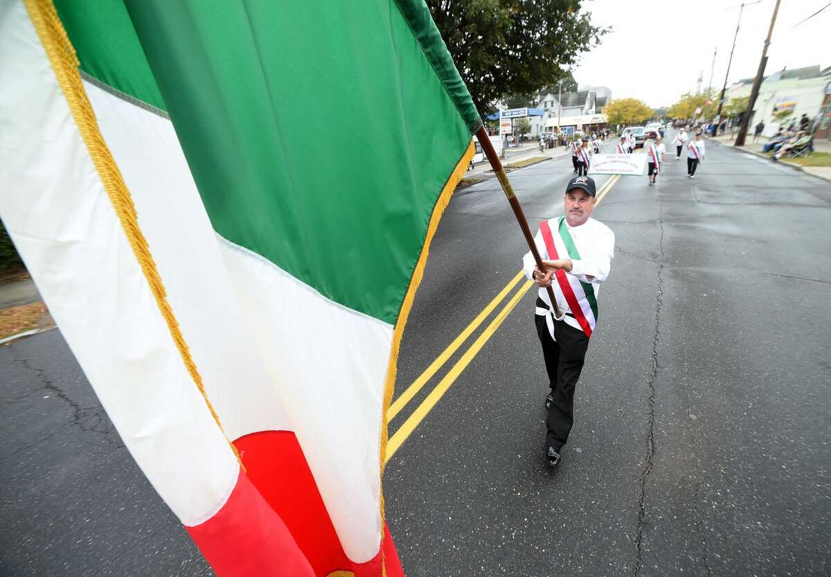 Paul Frosolone, president of the West Haven Italian American Club, carries the Italian flag up Campbell Ave. during the Greater New Haven Columbus Day Parade in West Haven on Oct. 8, 2017.