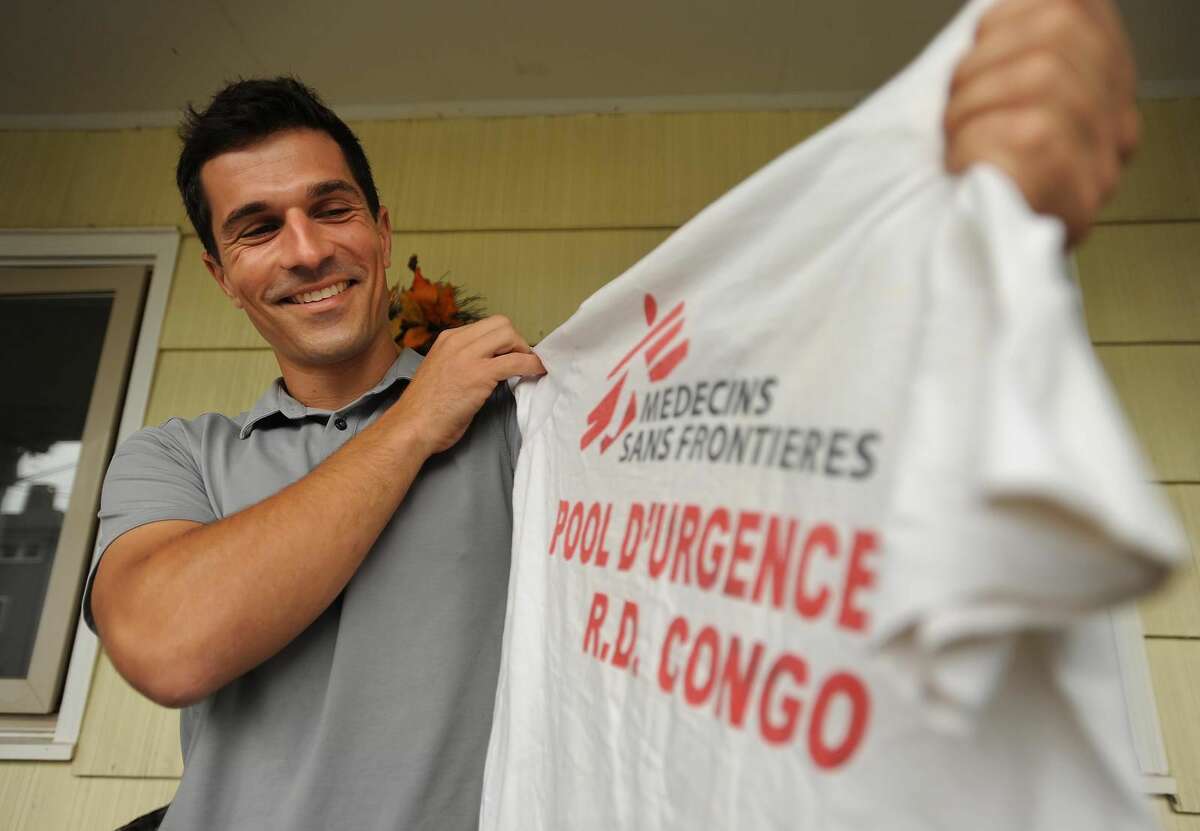 Kevin Bennett, of Milford, shows one of the shirts he wore during his recent eight month stint as a logistician with the group Medecins Sans Frontieres, or Doctors Without Borders, fighting outbreaks of cholera in the Democratic Republic of Congo.