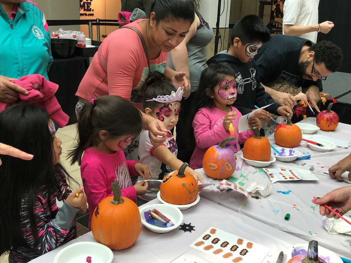 Kids decorate pumpkins to get into the holiday spirit.